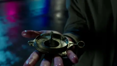 A detective stands on a rainy street corner, looking down at a mysterious brass compass in his palm. The needle is spinning wildly. Camera pulls back from a close-up of the compass to reveal the detective's puzzled face. Film noir, neon reflections on wet streets, heavy shadows.