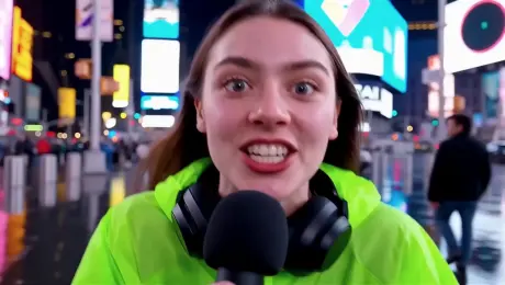 A vibrant young woman in her early 20s runs toward the camera in Times Square at night, ecstatic and wide-eyed, shouting passionately into a black microphone. She wears a neon green windbreaker and black headphones around her neck. She yells: “Yo, Wan2.5 just dropped on WaveSpeedAI — sound and texture are next level, try it right now!” Wet reflective streets, glowing blue-white-magenta billboards, blurred pedestrians, dynamic handheld follow-shot, sharp face focus, shallow depth of field. 4K UHD, saturated colors, viral UGC style.
