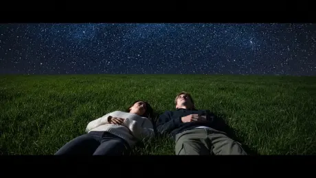 Two best friends lying in a grassy field under the stars, pointing at constellations. One says: "Do you ever think about how big the universe is?" The other replies: "All the time... and it still amazes me."