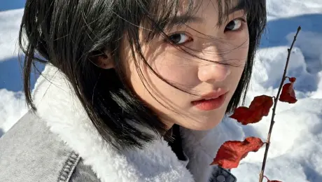 In soft golden afternoon light, a young girl stands amidst a forest of autumn maples, a vivid crimson leaf resting in her fingertips. She smiles subtly, her hair drifting in the breeze, as warm sunlight illuminates the leaf’s delicate veins.