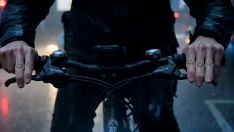 A 22-year-old delivery rider with noise-canceling headphones and a battered electric bike tears through a rain-soaked megacity at 2 AM, racing the clock.
Shot 1: Close-up — his hands squeeze the throttle to max, water spraying off the handlebars in sheets, delivery box strapped tight to the rack behind him.
Shot 2: Wide shot — he weaves between buses and taxis at full speed, neon reflections streaking across the flooded street beneath his tires like liquid fire.
Shot 3: POV shot — through his rain-spattered visor, a red light ahead, then a split-second decision — a hard lean into a narrow alley, bricks inches from his shoulder.
Shot 4: Close-up on the app screen zip-locked to his handlebars — 3 minutes remaining, 1.2 km left, rating: 4.97 — his jaw tightens.
Shot 5: He skids to a stop, yanks off his helmet, sprints the last 10 meters on foot to the door — rings the bell at exactly 2:00 AM — and exhales a breath he's been holding for six blocks.
Breathless and kinetic, soaked in city rain and the specific dignity of someone who refuses to be late.