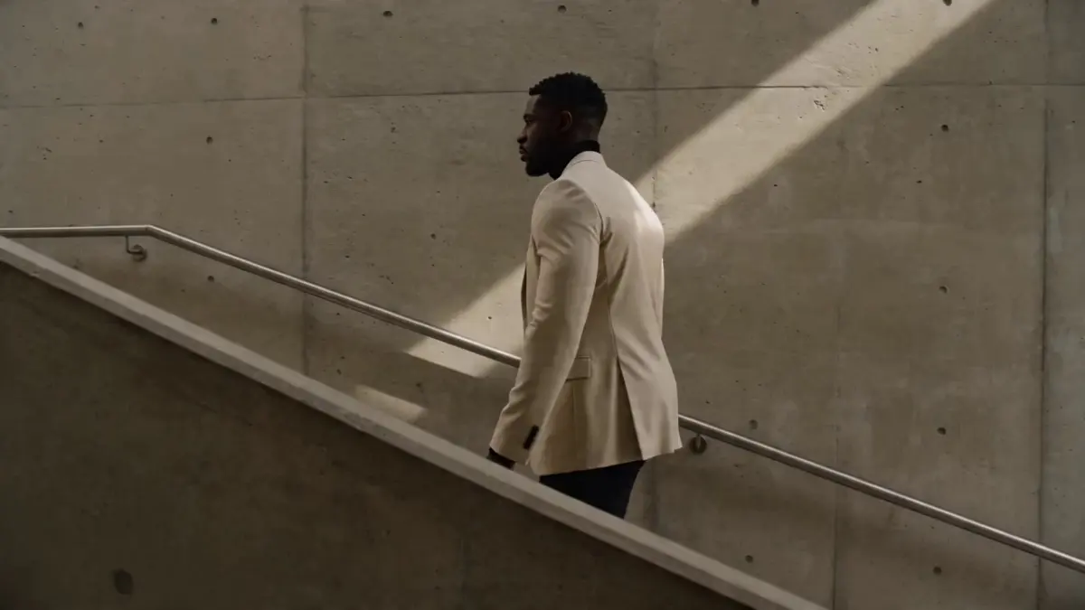 ltra high-end editorial photography, photorealistic, 8K, razor-sharp detail, perfect skin texture with natural pores and subsurface scattering, cinematic lighting, shot on medium format, Portrait: 31-year-old Black British architect in a cream blazer, standing in a brutalist concrete stairwell, soft directional skylight, composed posture, masterful color grading, natural catchlights in eyes, tactile fabric detail, magazine cover quality, no text, no logos, no watermarks