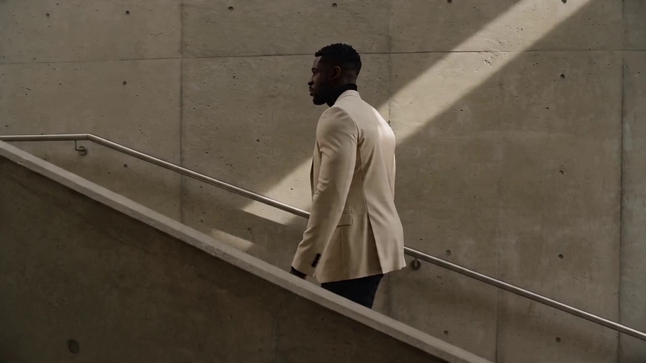 ltra high-end editorial photography, photorealistic, 8K, razor-sharp detail, perfect skin texture with natural pores and subsurface scattering, cinematic lighting, shot on medium format, Portrait: 31-year-old Black British architect in a cream blazer, standing in a brutalist concrete stairwell, soft directional skylight, composed posture, masterful color grading, natural catchlights in eyes, tactile fabric detail, magazine cover quality, no text, no logos, no watermarks