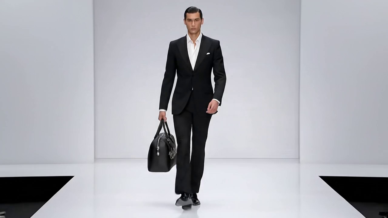 A man is catwalking with a bag that has a reference picture.